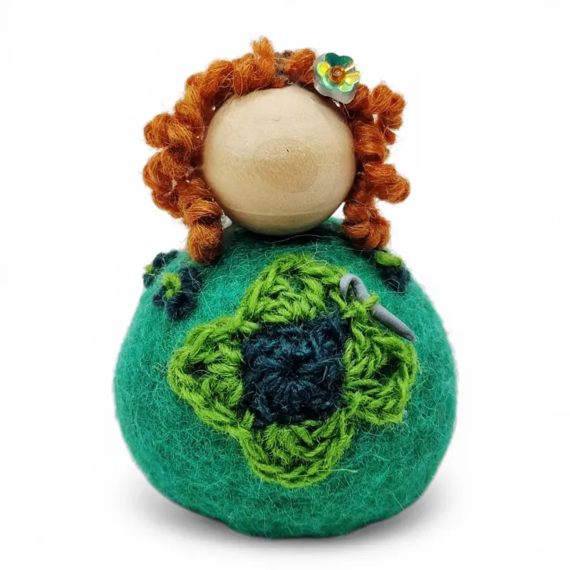 Handmade wool Crochet Lady Flóki wearing green dress holding a crochet needle. Iceland souvenir & gift.