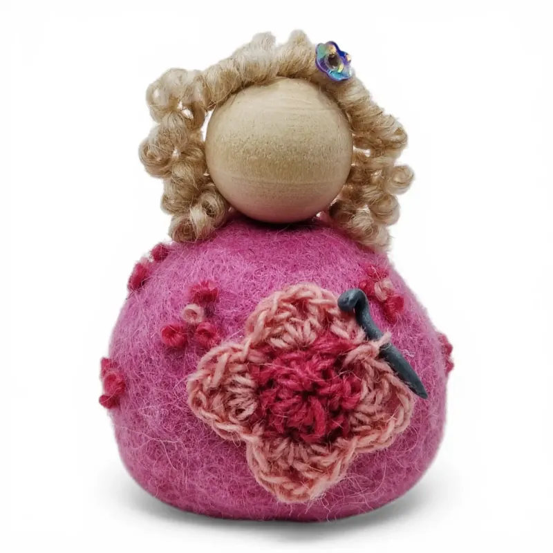 Handmade wool Crochet Lady Flóki wearing  light pink dress holding a crochet needle. Iceland souvenir & gift.