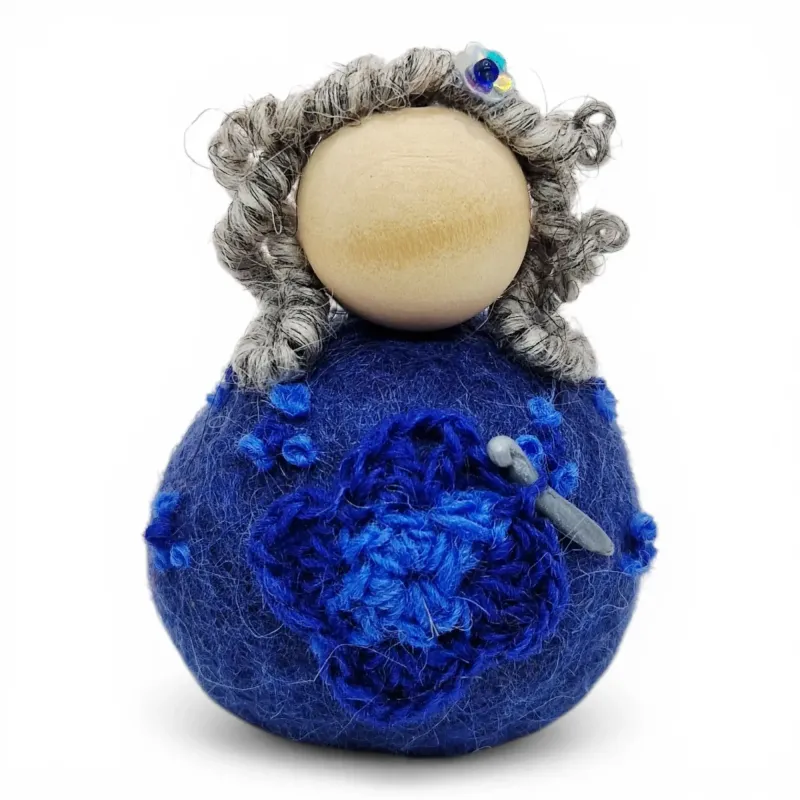 Handmade wool Crochet Lady Flóki wearing blue dress holding a crochet needle. Iceland souvenir & gift.