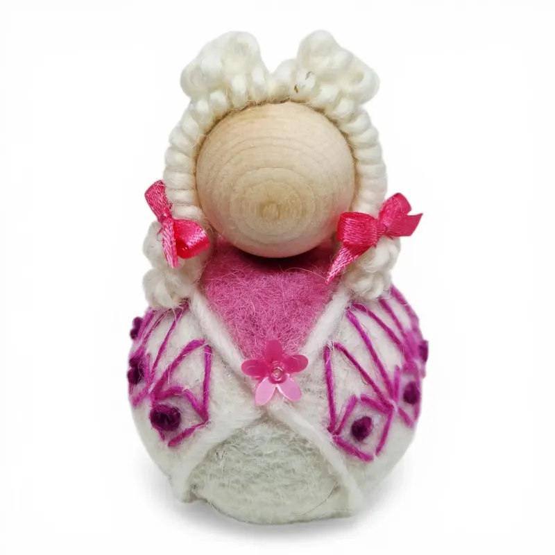 Handmade wool Summer Girl Flóki wearing light pink wool sweater with matching hair bow. Icelandic souvenir and gift