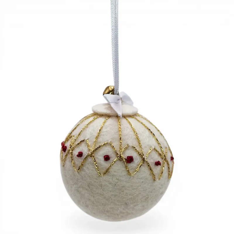 Handmade white wool Christmas ornament, traditional shimmering golden stitched pattern, red knots. Iceland souvenir & gift